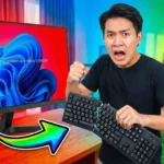 ชายไทยแสดงอาการโกรธขณะถือคีย์บอร์ดที่หักครึ่ง หน้าจอคอมพิวเตอร์ด้านหลังแสดงหน้าจอฟ้า (Blue Screen) และมีผู้หญิงแสดงอาการตกใจ